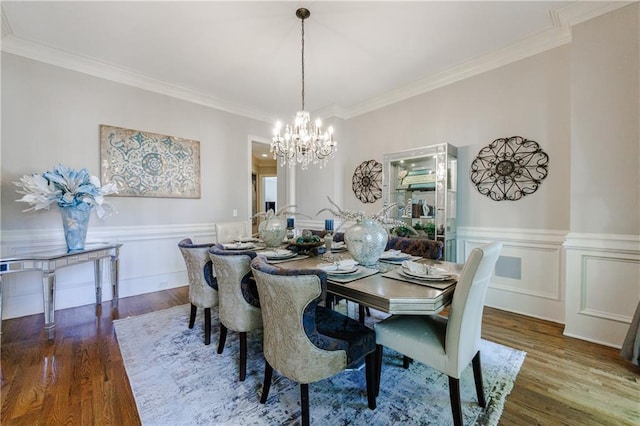 dining area featuring an inviting chandelier, wood-type flooring, and crown molding