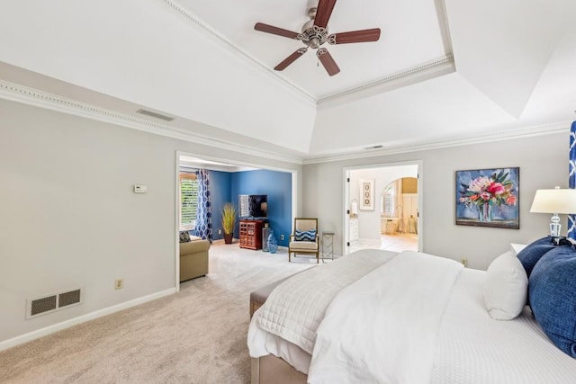 bedroom with a tray ceiling, light carpet, baseboards, arched walkways, and ornamental molding