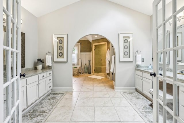 full bath with french doors, lofted ceiling, a shower stall, baseboards, and vanity