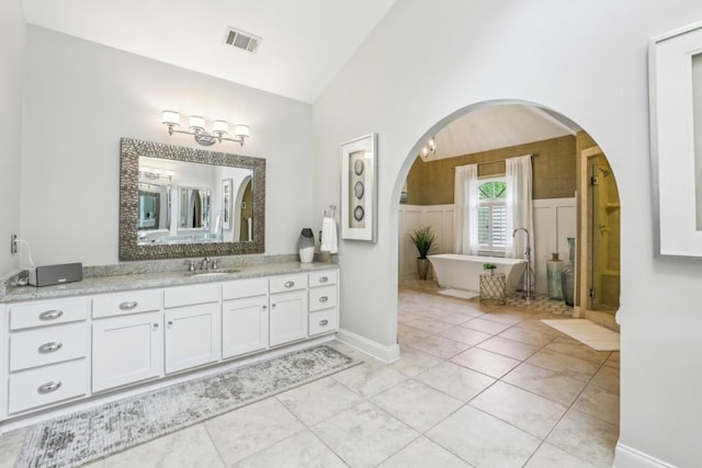 full bathroom featuring vanity, a soaking tub, and high vaulted ceiling