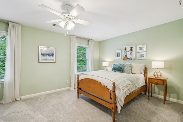 bedroom featuring light carpet, baseboards, and a ceiling fan