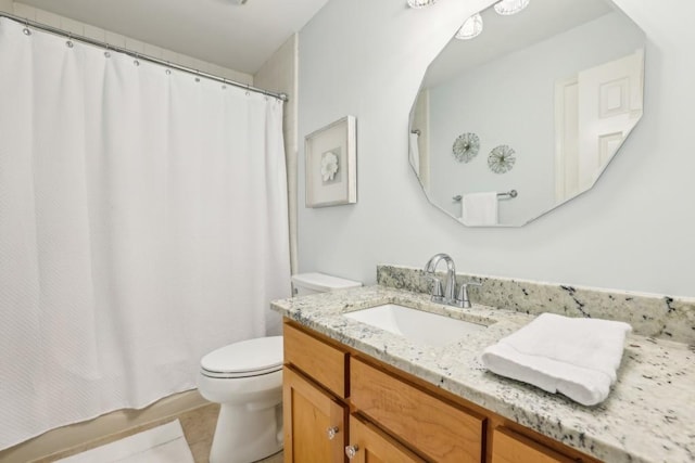 bathroom with toilet, vanity, and tile patterned flooring