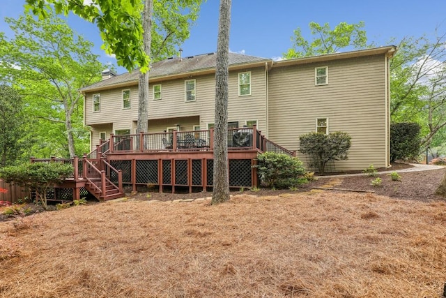 back of property featuring stairs, a deck, and a chimney