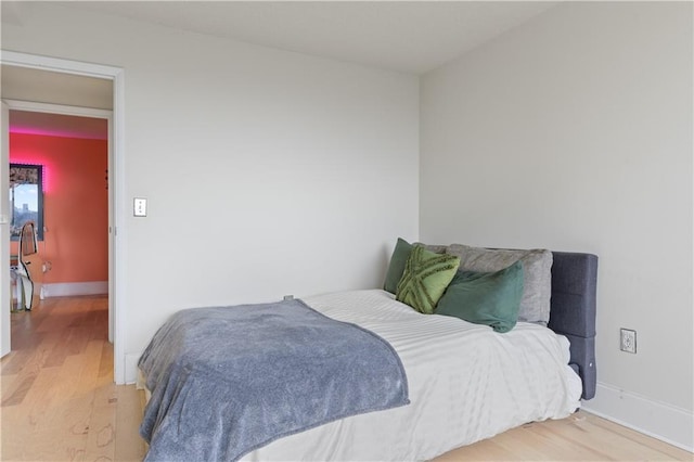 bedroom with baseboards and wood finished floors