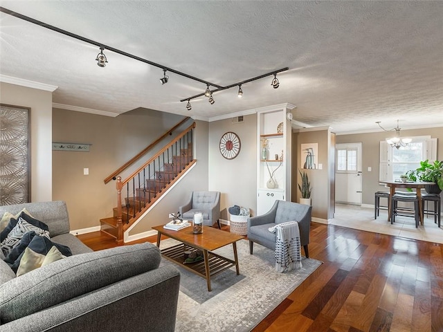 living area with visible vents, stairway, ornamental molding, wood finished floors, and a textured ceiling