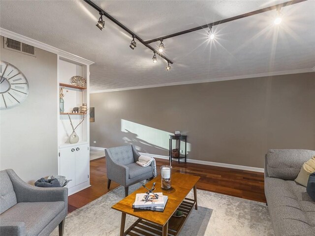 living room featuring hardwood / wood-style flooring, crown molding, a notable chandelier, and a textured ceiling