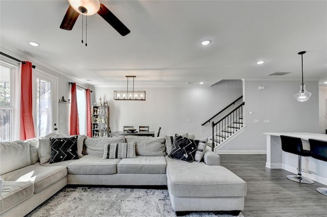 living room with ornamental molding, hardwood / wood-style floors, and ceiling fan