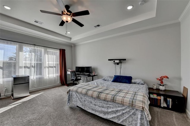 carpeted bedroom featuring crown molding, a tray ceiling, and ceiling fan