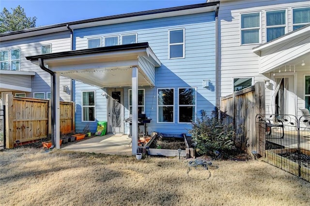 rear view of house featuring a patio and a lawn