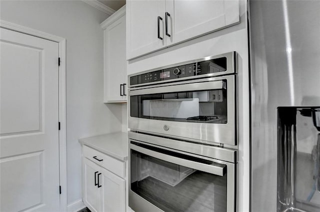 kitchen featuring white cabinetry, crown molding, and appliances with stainless steel finishes