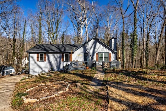 view of front of house featuring driveway and a chimney