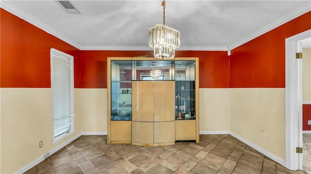 unfurnished dining area with ornamental molding and an inviting chandelier