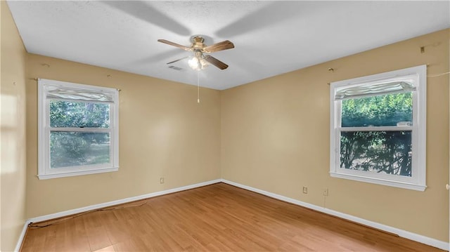 unfurnished room featuring ceiling fan, plenty of natural light, and hardwood / wood-style floors