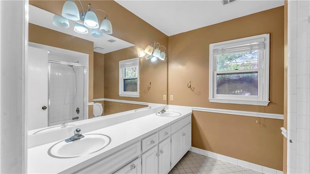 bathroom with a shower with door, vanity, and a wealth of natural light