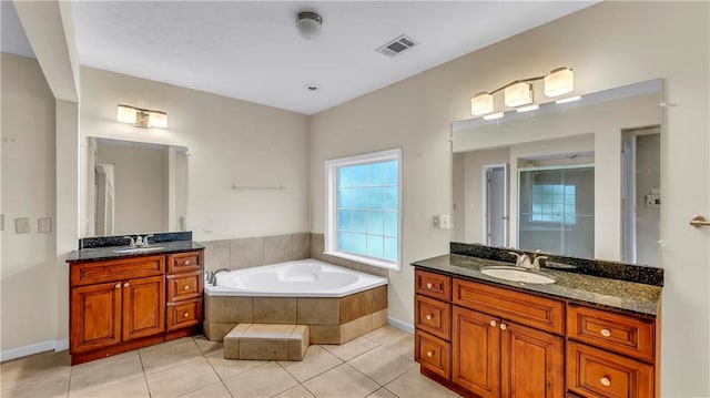 bathroom with vanity, tile patterned floors, and a relaxing tiled tub