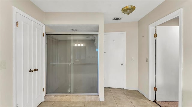 bathroom featuring tile patterned flooring and a shower with shower door