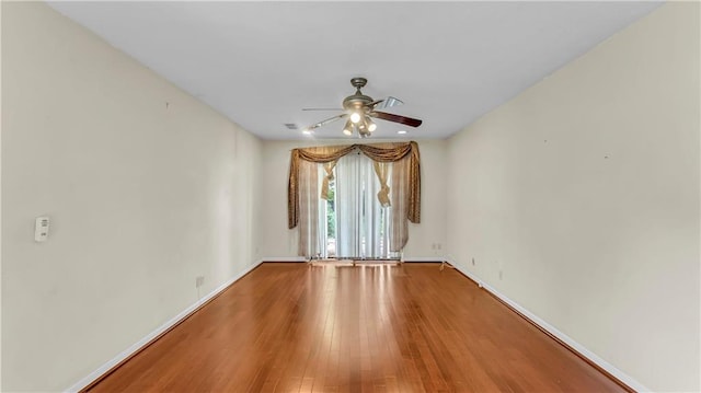 empty room with ceiling fan and hardwood / wood-style flooring