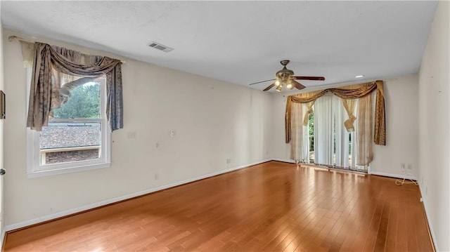 empty room with hardwood / wood-style floors and ceiling fan