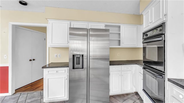 kitchen with light wood-type flooring, stainless steel refrigerator with ice dispenser, double oven, and white cabinets