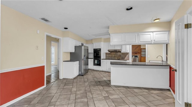 kitchen with white cabinets, double oven, stainless steel refrigerator with ice dispenser, and kitchen peninsula