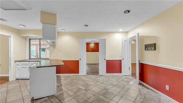 kitchen featuring white cabinetry, light tile patterned floors, and sink