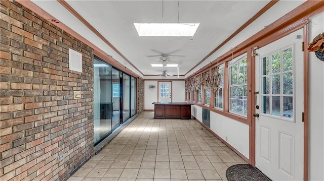 unfurnished sunroom with ceiling fan and a skylight