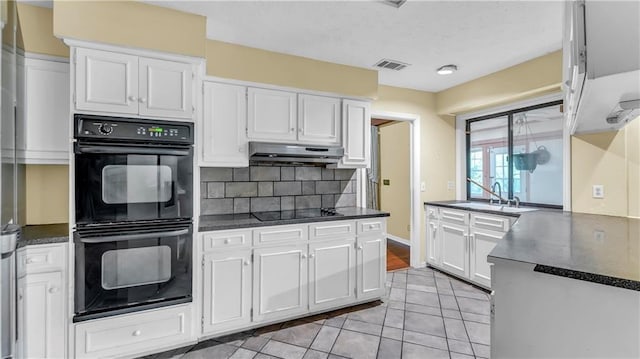 kitchen featuring white cabinets, sink, black appliances, range hood, and decorative backsplash