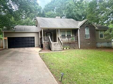 single story home with a front yard, an attached garage, covered porch, a chimney, and concrete driveway