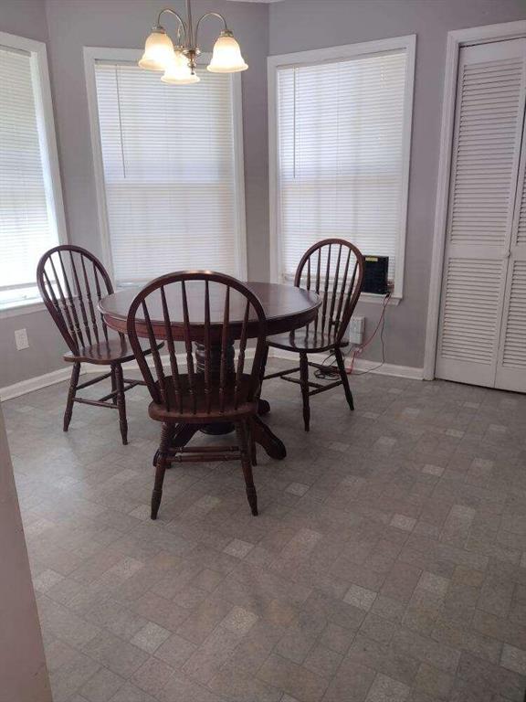 dining room with baseboards and a notable chandelier