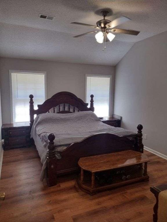 bedroom with visible vents, multiple windows, vaulted ceiling, and a textured ceiling