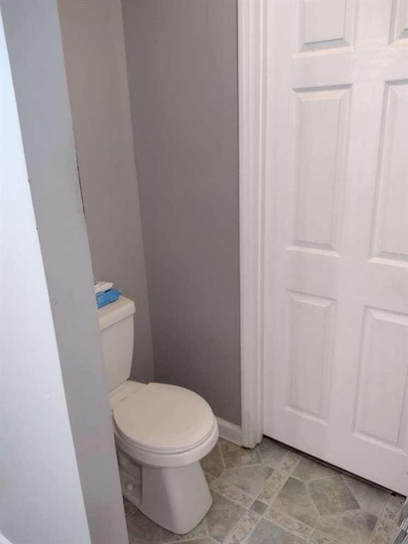bathroom featuring toilet and baseboards