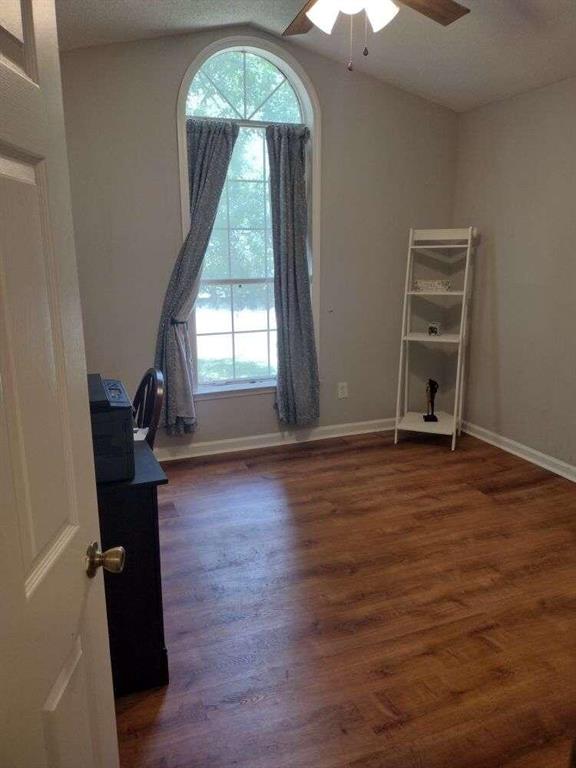 unfurnished room featuring baseboards, a ceiling fan, and wood finished floors