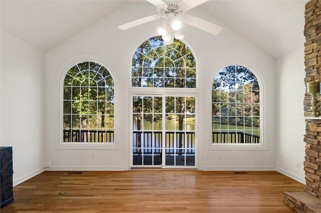 doorway to outside featuring hardwood / wood-style flooring, ceiling fan, and high vaulted ceiling