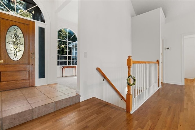 entrance foyer featuring wood-type flooring, high vaulted ceiling, and a wealth of natural light