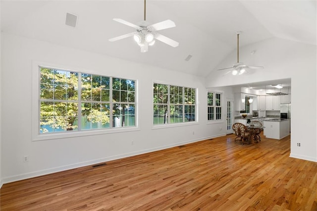 unfurnished living room featuring light hardwood / wood-style flooring, ceiling fan, and lofted ceiling