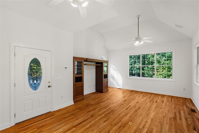 foyer entrance featuring ceiling fan, light hardwood / wood-style floors, and vaulted ceiling