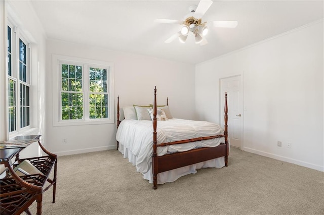 carpeted bedroom with ceiling fan and ornamental molding