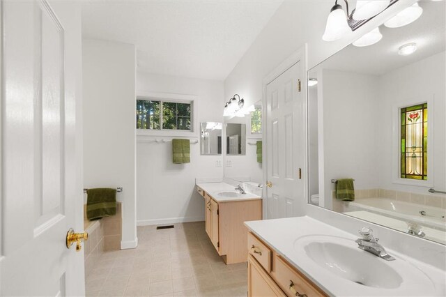 bathroom featuring tile patterned floors, vanity, and a bath