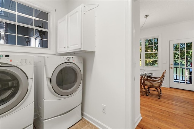 clothes washing area featuring light hardwood / wood-style floors, cabinets, separate washer and dryer, and ornamental molding