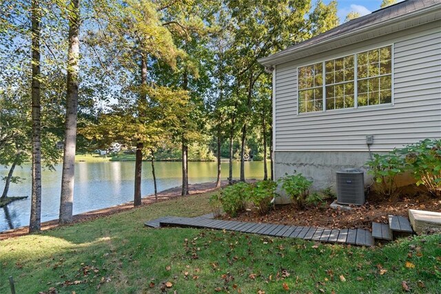 view of yard with a water view and central AC