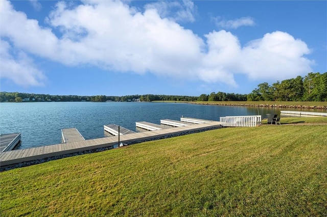 view of dock with a yard and a water view