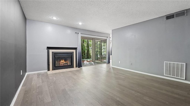 47 Arbor End, Smyrna, GA 30080 - unfurnished living room featuring wood finished floors, a textured ceiling, and a fireplace with flush hearth