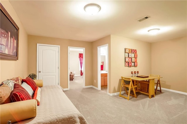 bedroom featuring light colored carpet and ensuite bath