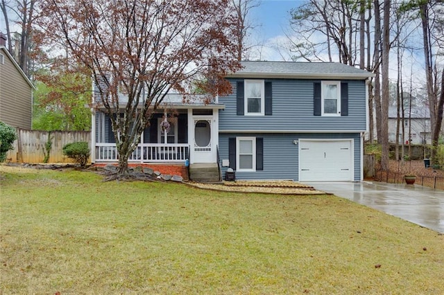 tri-level home featuring a front lawn, fence, covered porch, driveway, and an attached garage