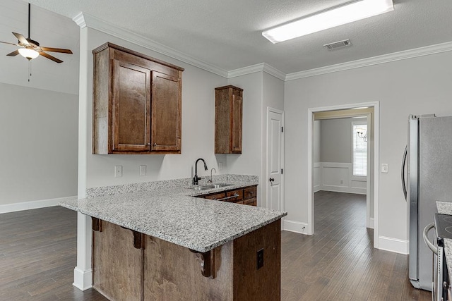 63 Emma Ln, Winder, GA 30680 - kitchen with appliances with stainless steel finishes, a sink, dark wood-style flooring, ornamental molding, and a peninsula