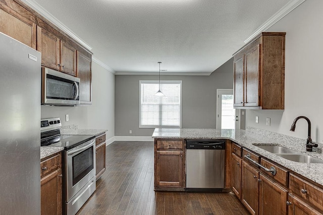 63 Emma Ln, Winder, GA 30680 - kitchen with appliances with stainless steel finishes, a sink, a peninsula, ornamental molding, and dark wood-style floors