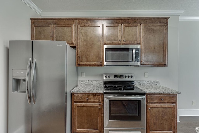 63 Emma Ln, Winder, GA 30680 - kitchen with stainless steel appliances, ornamental molding, light stone countertops, and baseboards