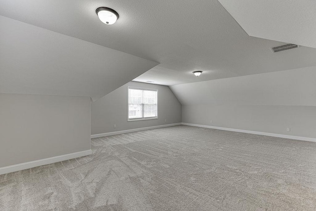 63 Emma Ln, Winder, GA 30680 - additional living space with lofted ceiling, carpet flooring, baseboards, and a textured ceiling