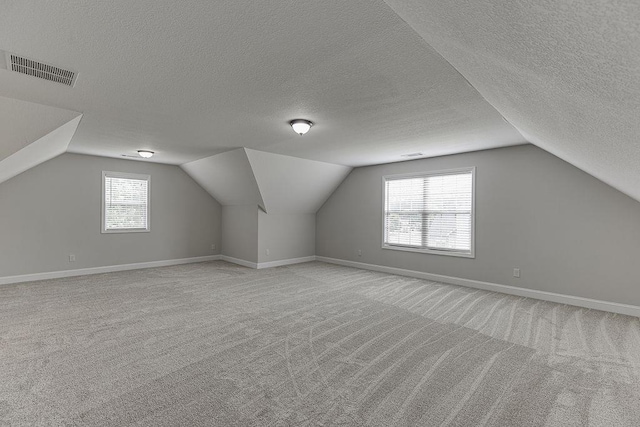 63 Emma Ln, Winder, GA 30680 - bonus room featuring light colored carpet, a textured ceiling, vaulted ceiling, and baseboards