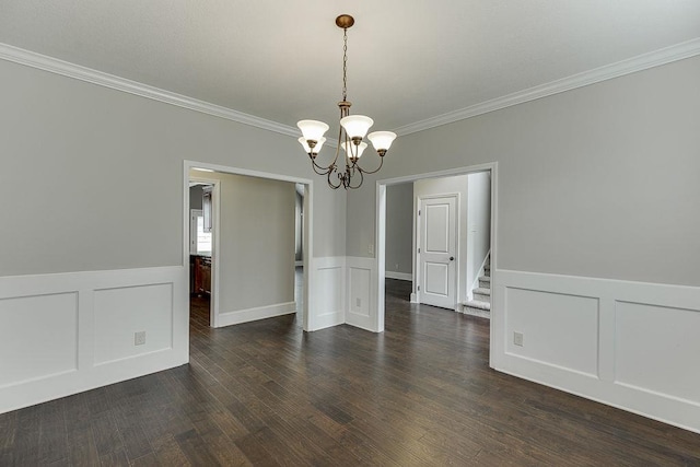 63 Emma Ln, Winder, GA 30680 - spare room with a chandelier, crown molding, a decorative wall, a wainscoted wall, and dark wood-style floors